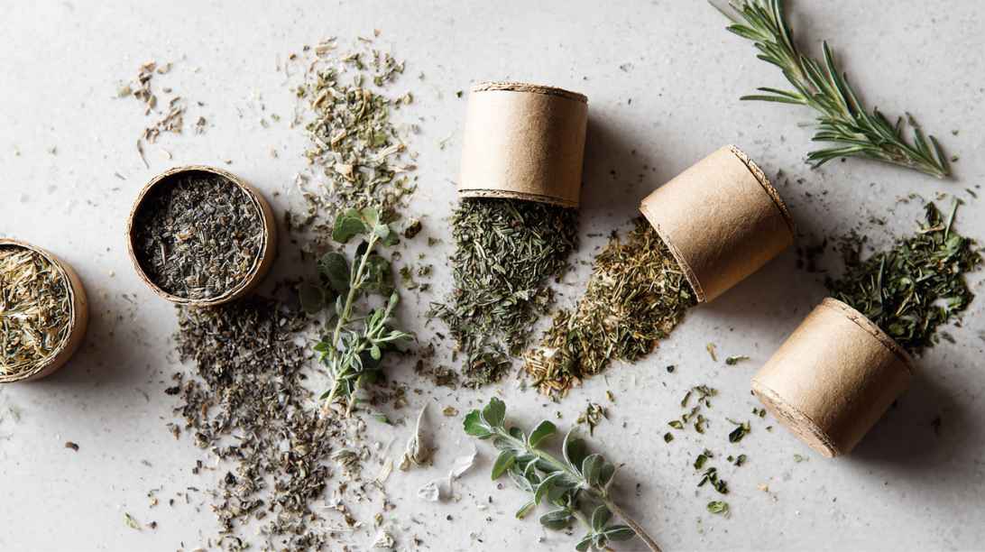 kartonnen potjes met gedroogde biologische kruiden en verse kruiden
